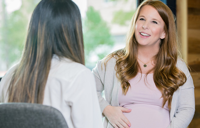 Schwangere Frau spricht mit Ärztin